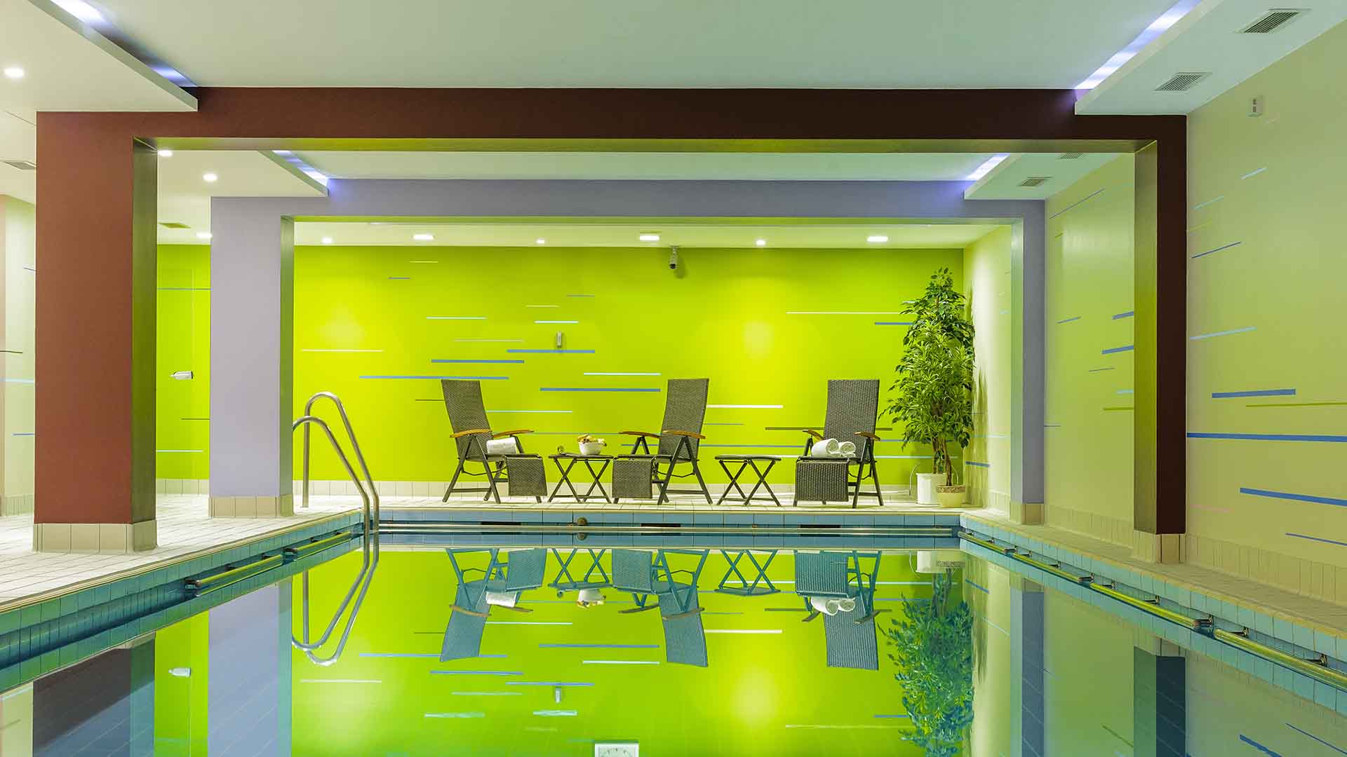 Pool with accent wall and loungers