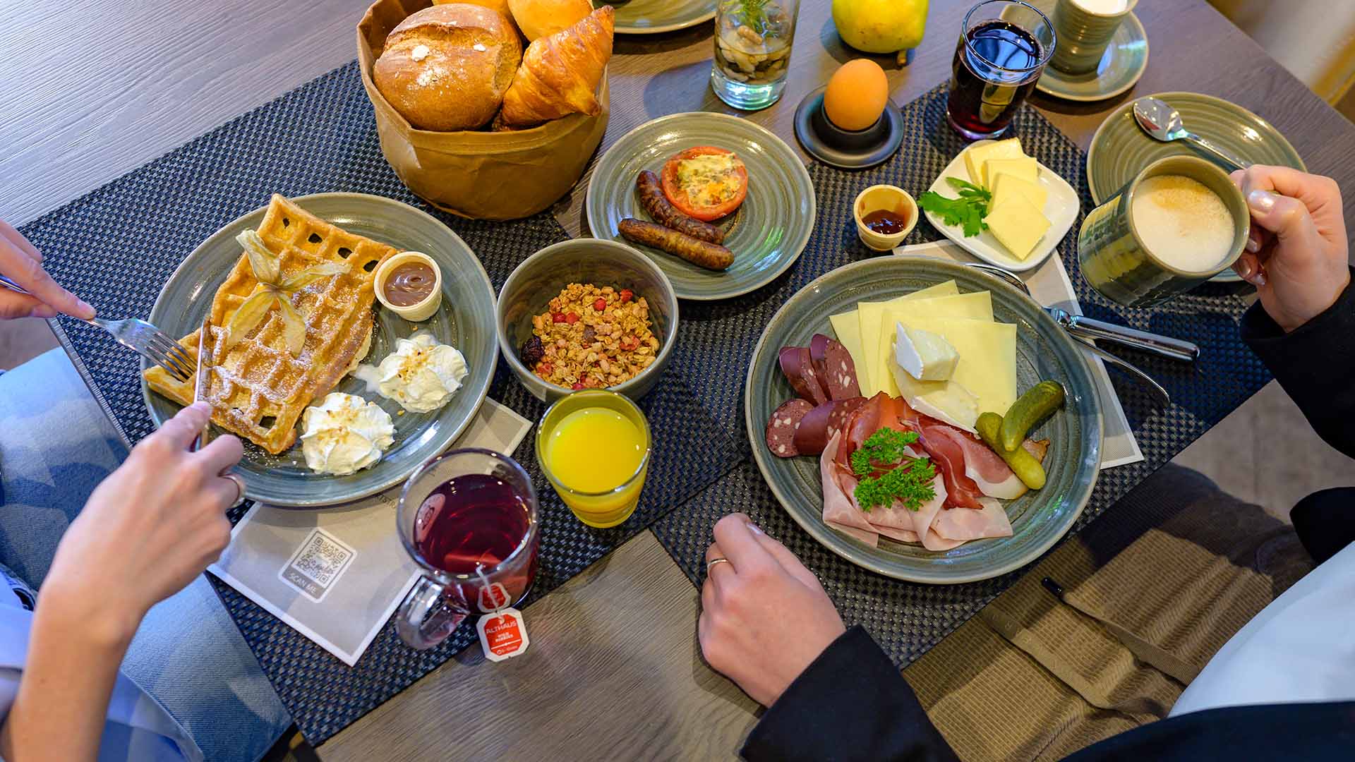 Two guests at a generously laid breakfast table